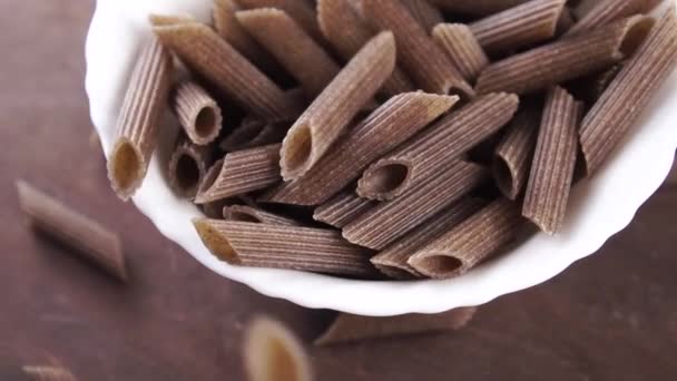 Full Bowl Uncooked Brown Buckwheat Organic Pasta Falling Slow Motion — Stock Video