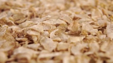 Kurutulmamış mısır gevrekleri yığının üzerine düşüyor. Sağlıklı kahvaltı malzemesi konsepti. Makro. Dolly vurdu.