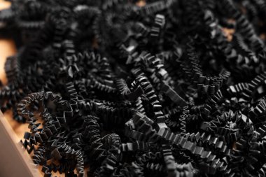 Siyah kağıt, içi boş karton hediye kutusuna doldurulmuş.