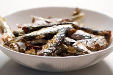 Geleneksel kavrulmuş sardalyalar ev mutfak masasında yakın plan beyaz tabakta.