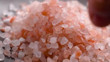 Parmaklar bir tutam Himalaya pembe organik tuz topluyor. Makro çekim