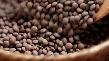 Köy mutfağında karıştırılmış çiğ kahverengi mercimek. Kuru organik besin bileşeni