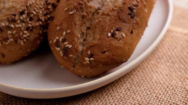 El, susamlı ve keten tohumlu taze ekmek alır.