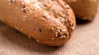 Taze buğday ekmeği, çıtır ekmek kabuğu ve kabuklu kumaş üzerinde tüm tohumlar.