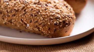 Seramik tabakta taze, çıtır çıtır tahıllı ekmek.