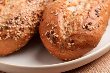 Üzerine susam ve keten tohumları seramik bir tabakta servis edilen altın çıtır çıtır mini baget.