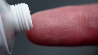 Nemlendirici kozmetik krem bir tüpten parmak derisine dağıtılıyor. Makro