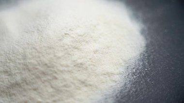 Siyah seramik tabakta beyaz protein tozu. Fitness beslenme konsepti. Döndürme