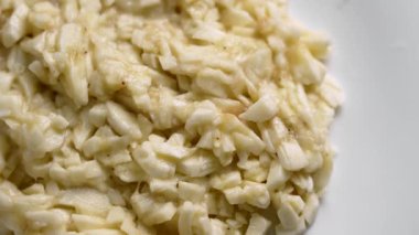 Seramik bir mutfak tabağında ince ince doğranmış muz. Besleyici diyet gıda konsepti