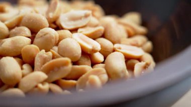 Ahşap kasede kavrulmuş tuzlanmış fıstık yakından görülüyor. Deniz tuzu kristalli altın çekirdekler