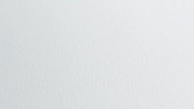 Beyaz bir yüzey boyunca parmaklarıyla hareket eden yuvarlak bir kabarcık seviyesi. Hassas bir ölçüm aleti..