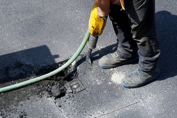Yol bir gaz boru hattında çalışıyor, gaz bağlantısını ortaya çıkarmak için bir kaya matkabıyla asfalt bir yolda yükseliyor.