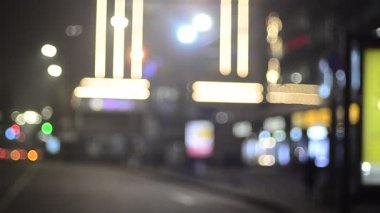 Aydınlatılmış bina ve trafik ışıklarını takip eden kamera ile odaklanmış akşam sahnesi