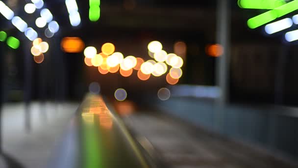 在黑暗中照明的有轨电车车站的非集中镜头 背景为道路交通灯 — 图库视频影像