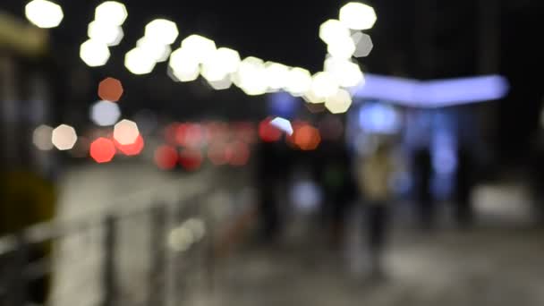 与行人在街上散步的灯光的分散焦点的晚间画面 — 图库视频影像