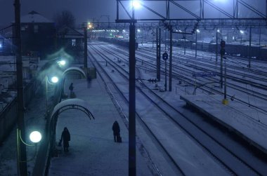 Karlı demiryolu manzarası geceleri aydınlatılıyor.
