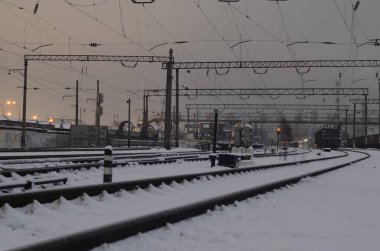 Alacakaranlıkta raylı karlı demiryolu manzarası