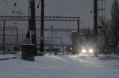 Karlı demiryolu manzarası geceleri aydınlatılıyor.