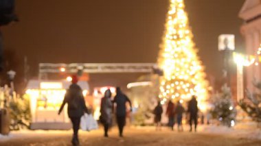 Kyiv 'deki noel pazarında insanların odak noktasından çıkarılmış görüntüleri ve aydınlatılmış köknar ağacı