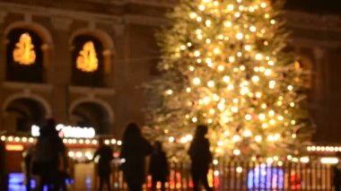 Kyiv 'deki noel pazarında insanların odak noktasından çıkarılmış görüntüleri ve aydınlatılmış köknar ağacı