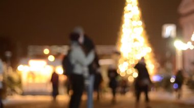 Kyiv 'deki noel pazarında insanların odak noktasından çıkarılmış görüntüleri ve aydınlatılmış köknar ağacı