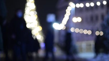 Kyiv 'deki noel pazarında insanların odak noktasından çıkarılmış görüntüleri ve aydınlatılmış köknar ağacı
