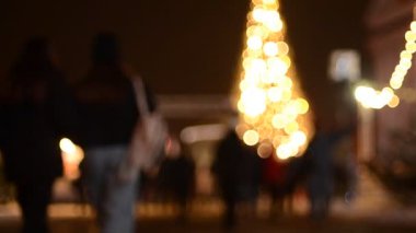 Kyiv 'deki noel pazarında insanların odak noktasından çıkarılmış görüntüleri ve aydınlatılmış köknar ağacı