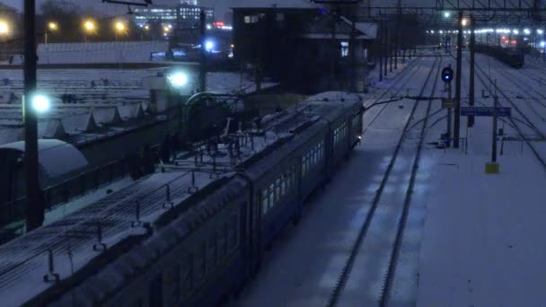 Zug Fährt Nachts Auf Gleisen Beleuchteter Verschneiter Bahnlandschaft — Stockvideo