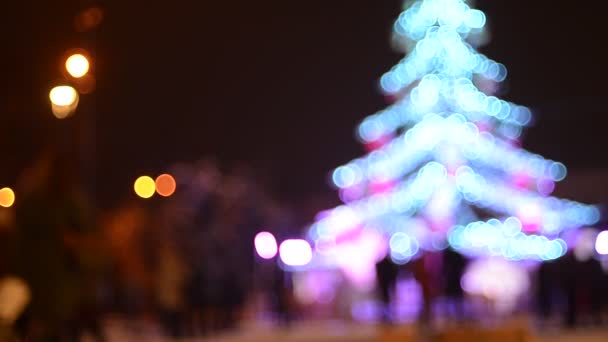 与街上的人一起旋转照明冷杉树的分散焦距镜头 — 图库视频影像