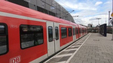 Metro istasyonunda hareket eden kırmızı trenli bir adam var.