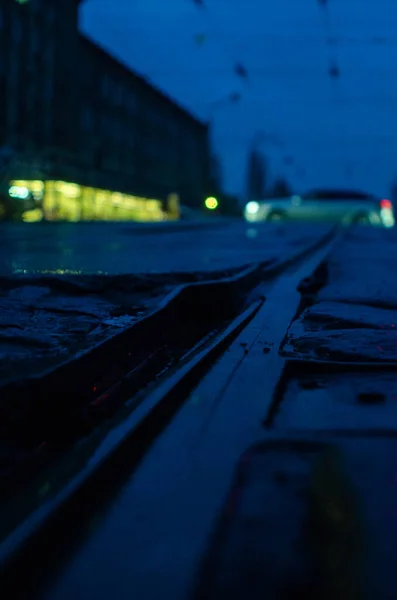 Blick Auf Straßenbahnschienen Auf Beleuchtetem Nassen Asphalt — Stockfoto