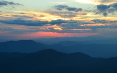 Gün batımı gökyüzü ile dağlık manzaranın manzarası
