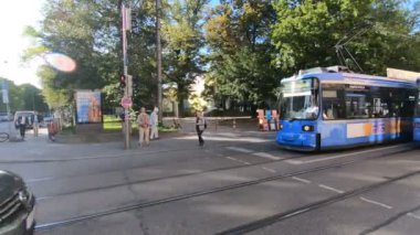 Ulaşım manzarası ve güneşli caddedeki insanlar