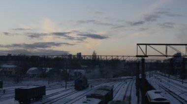 Tren, alacakaranlıkta raylarla karlı tren sahnesinde hareket ediyor.