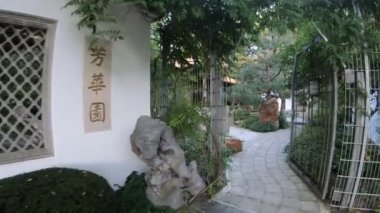 Binaları ve yeşillikleri olan Japon bahçesinin yürüyüş manzarası 