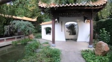 Binaları ve yeşillikleri olan Japon bahçesinin yürüyüş manzarası 
