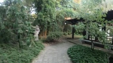 Binaları ve yeşillikleri olan Japon bahçesinin yürüyüş manzarası 