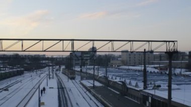 Tren, alacakaranlıkta raylarla karlı tren sahnesinde hareket ediyor.