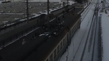 Tren alacakaranlıkta karlı tren raylarında hareket ediyor.