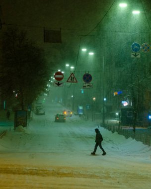 Karlı Kyiv Caddesi 'nden geçen adam gece aydınlandı.