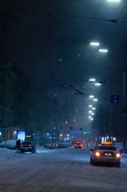 Akşamları yol trafiği aydınlandı ve Ukrayna 'daki Kyiv şehir caddesi karla kaplandı