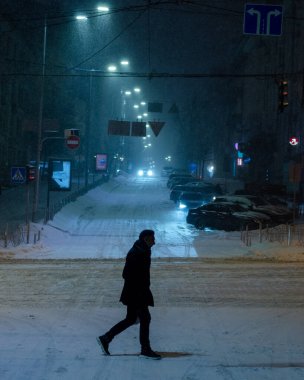 Karlı Kyiv Caddesi 'nden geçen adam gece aydınlandı.