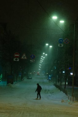 Karlı Kyiv Caddesi 'nden geçen adam gece aydınlandı.