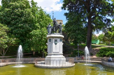 pool with fountains and sculptures in green and sunny park