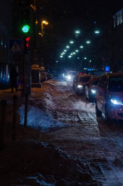 Akşamları yol trafiği aydınlandı ve Ukrayna 'daki Kyiv şehir caddesi karla kaplandı