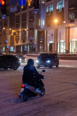 Akşamları yol trafiği aydınlandı ve Ukrayna 'daki Kyiv şehir caddesi karla kaplandı