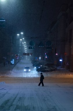 Karlı Kyiv Caddesi 'nden geçen kişi gece aydınlandı.