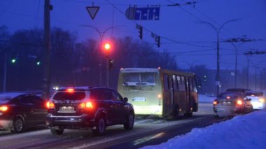 Trafik görüntüleri, karlı yolda akşam ışığında hareket eden arabalar.