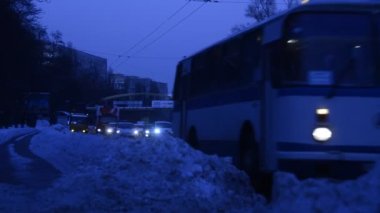 Trafik görüntüleri, karlı yolda akşam ışığında hareket eden arabalar.