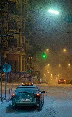 Akşamları yol trafiği aydınlandı ve Ukrayna 'daki Kyiv şehir caddesi karla kaplandı